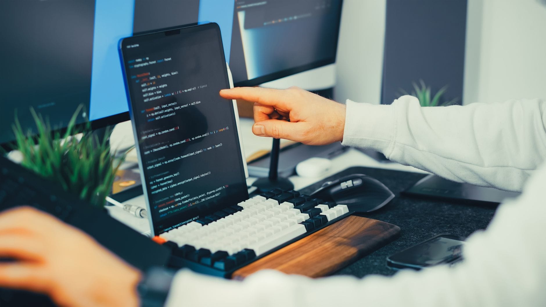 Programista testujący kod open source na laptopie i monitorze w biurze
